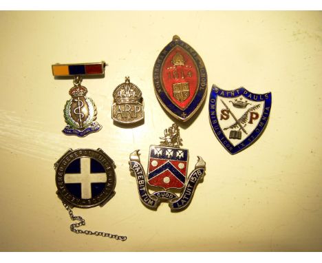 A silver ARP Badge, two others, a silver and enamel school badge etc.