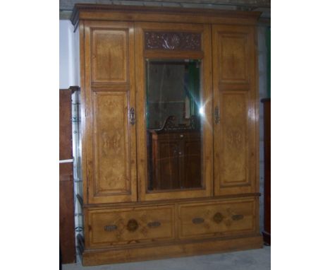An Edwardian figured oak Wardrobe with dentil cornice, centre bevelled mirror panel door, with carved decoration and two draw