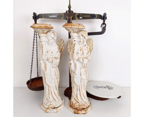 A pair of painted cast iron candlesticks, in the form of angels, 49 cm high, and a set of scales and weights (qty)