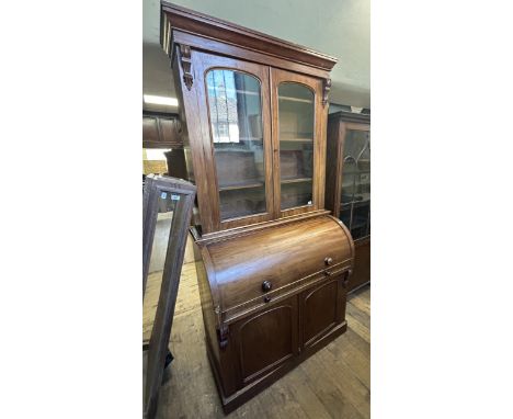 A 19th century mahogany cylinder bookcase cabinet, the top having two glazed doors, above a cylinder front to reveal a fitted