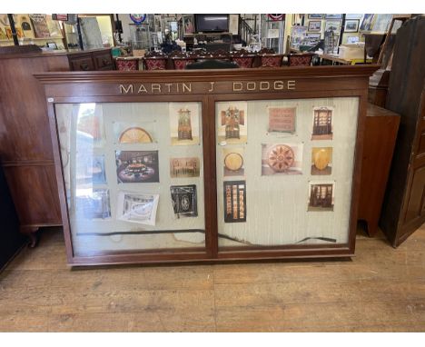 A wall mounted display cabinet, freeze reading Martin J Dodge, with two glazed doors, 122 x 192 cm&nbsp; Provenance: Sold on 