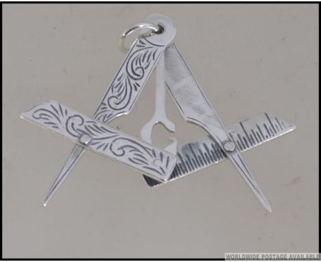 A silver Masonic symbol with rule and compass. Weight 5.3g