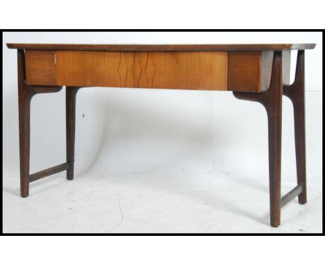 A 1970's Danish influence teak wood console hall table raised on tapered legs with return stretchers. Above a shaped frieze w
