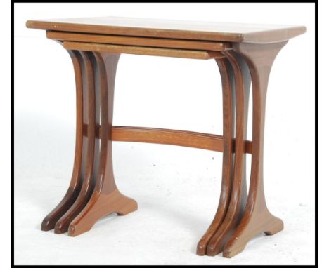 A 1970's G-Plan teak wood nest of tables raised on shaped supports with bow stretchers to each table. Measures: 52cms high x 