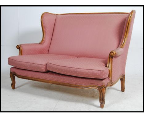 A 20th century French canape - 2 seat fauteuil sofa having a reeded show wood walnut frame with pink upholstered frame. Measu