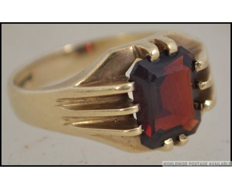 A vintage 9ct gold and cushion cut ruby garnet stone ring being claw mounted. Birmingham hallmarks. Size T / Weight 6.5g