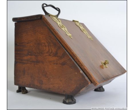 A 19th century elm and brass coal scuttle. The elm body with hinged top having exterior polished brass bracket work and handl