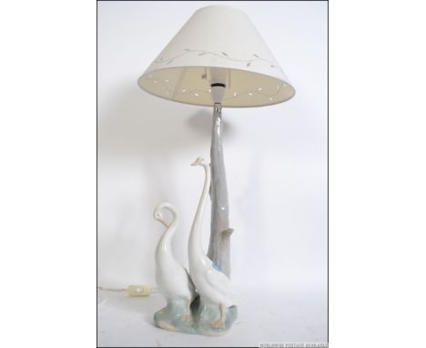 A good Nao Spanish ceramic table lamp having base of goose being raised on naturalistic plinth. Complete with the shade. Meas