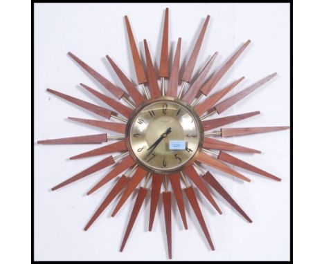 A vintage 1950's teak and gilt metal sunburst clock with gilt dial, notation for Anstey & Wilson. Measures: 62cms diameter.