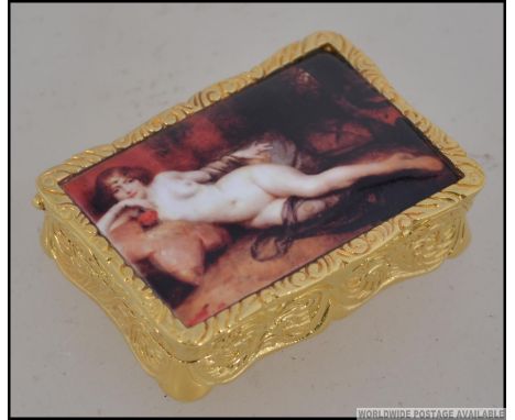 A gold plated on silver rococo style pill box with nude erotic enamel image to the lid. Stamped to base. Weight 61.5g. Measur