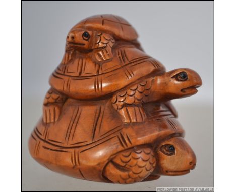 A carved Japanese wooden netsuke of three tortoises ( see illustrations )