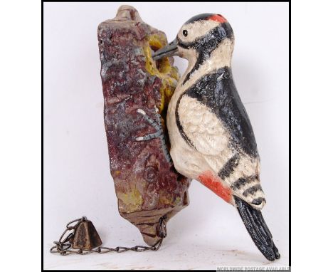 A cast iron Woodpecker door knocker. When knocked the Woodpecker pecks a tree. 13cm long. 