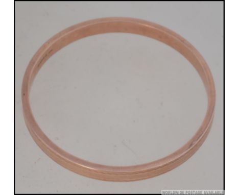 A 9ct gold hallmarked rose gold slave bangle. The inside stamped for Cheshire assay office, date letter y, makers NG&S. Total