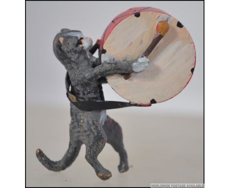 An unusual cold painted bronze miniature pug dog playing a large drum being handpainted. Measures 4cm high.