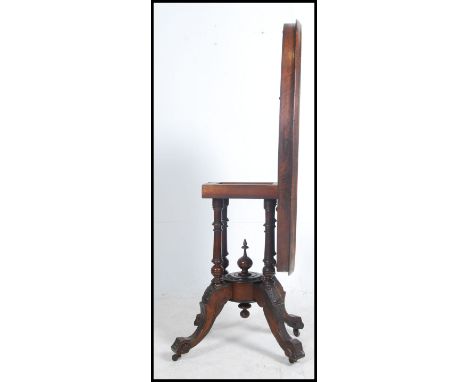 A Victorian mahogany marquetry inlay centre table, the oval tilt top raised on an arrangement of four turned moulded supports