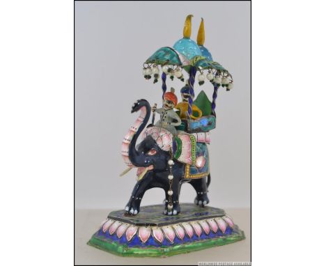 A late 19th / early 20th century silver and enamel model of an elephant with a howdah atop. The roof of the howdah with pearl