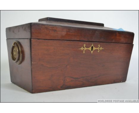 A Georgian rosewood inlaid sarcophagus shaped tea caddy complete with the twin sectional caddy's to the interior with mixing 