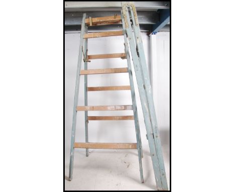 A pair off vintage mid century vintage wooden builders trestle stands with metal clasp to the top, painted frames.