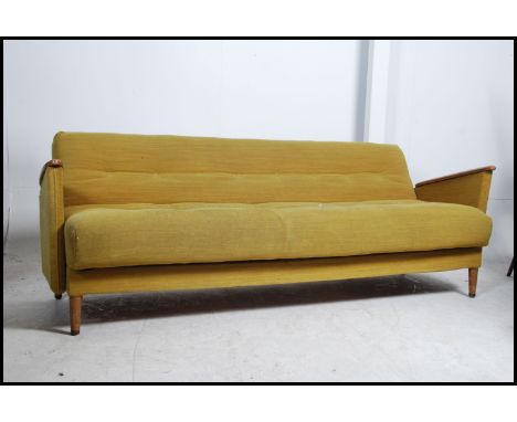 A 1960's original teak Danish influence sofa day bed in the manner of Scandart. The show wood teak frame with stunning angula