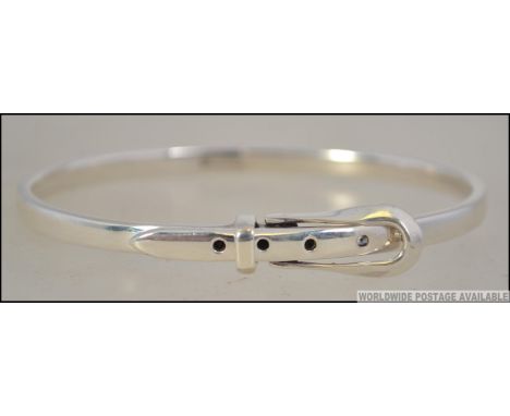 A silver ladies bangle in the shape of a belt dating to the 20th century, the belt buckle being adjustable. Size 5.5cms diam 