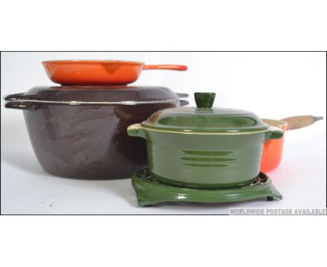 A collection of Le Creuset pans and lids to include a Skillet pan, saucepan with lid another pan along with a similar style e