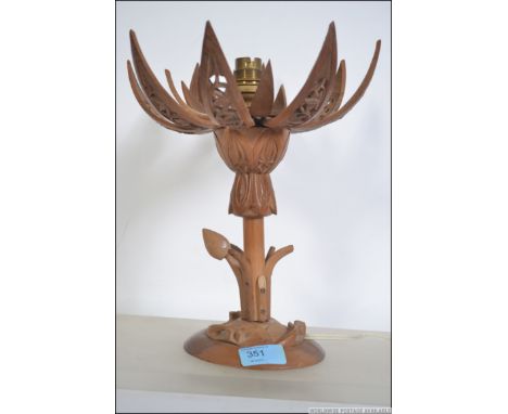 A mid century hardwood asiatic metamorphic table lamp having expanding flower bulb head top revealing light. Measures 33cm hi