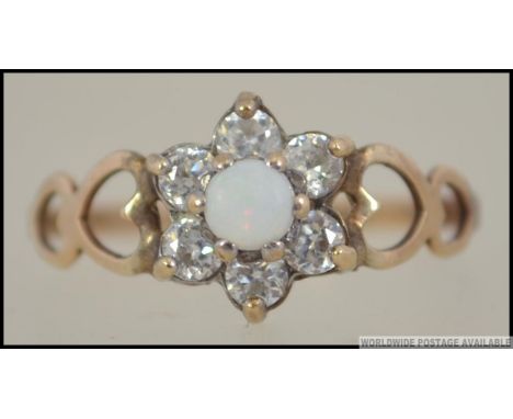 A 975 sterling gilt silver opal flower head cluster ring. The surrounding cz's approx  20pnts with central cabochon opal. Sta