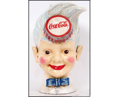 A vintage style, 20th century cast iron Coca Cola money bank of a young boys head. 21cm long