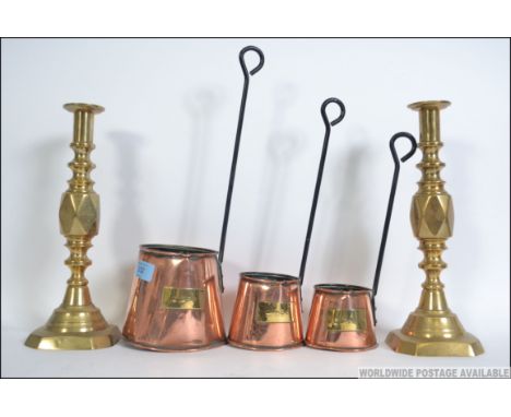 3 vintage copper and brass Cider ladles each with brass plaques together with a pair of brass tall candlesticks