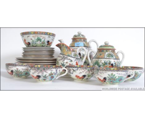 An early 20th century Chinese Cantonese tea service decorated with scenes of fighting cocks, peony trees and fauna with geome
