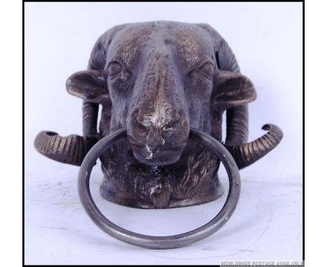 A cast iron door knocker of a Rams head. 21cm long. 