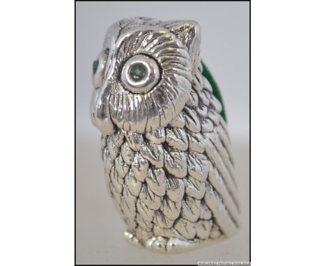 A silver stamped 925 owl shaped pin cushion with emerald eyes having green velour cushion to back. Weight 18.1g. Measures 4cm