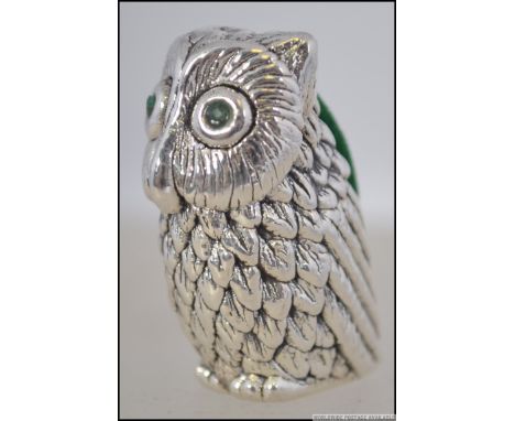 A silver stamped 925 owl shaped pin cushion with emerald eyes having green velour cushion to back. Weight 18.1g. Measures 4cm