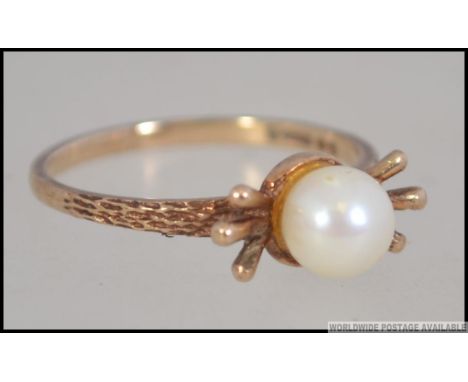 A 9ct gold hallmarked pearl ring with flash bow setting being marked for London possibly 1962. Size M / weight 1.8g