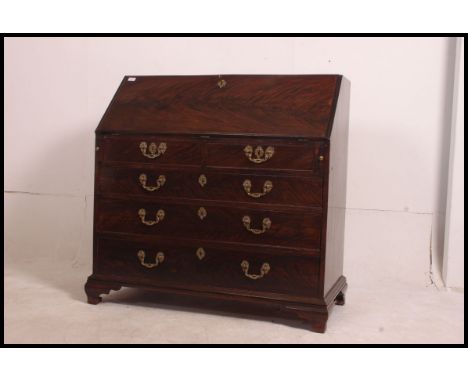An early 19th century Georgian solid mahogany bureau desk. The hinged top enclosing a architectural fitted interior above a c