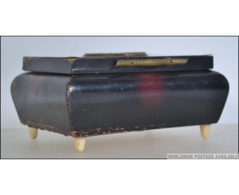 A bone inlaid panel top musical cigarette case having pictorial centre dating to the mid 20th century. The box playing Callpp