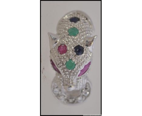 A silver ladies Panther ring inset with semi-precious stones and ruby eyes. Size R / Weight 5.6g