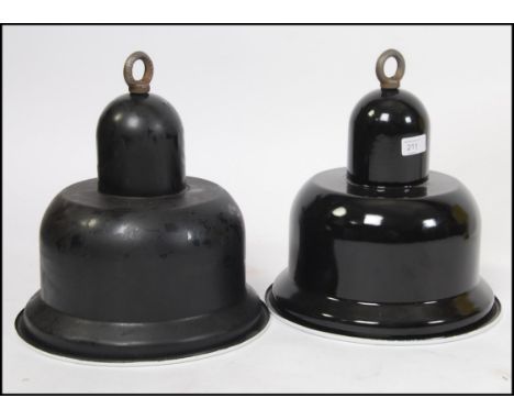 A pair of Industrial 20th century black and white enamel factory pendant shades of unusual shape having original bulb fitment