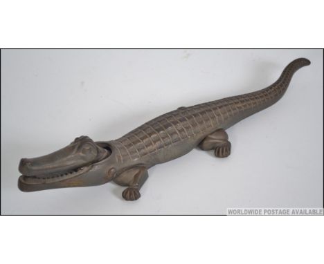 A vintage early 20th century pair of cast metal nut crackers in the form of a crocodile. Stamped to the inside Neston Made in