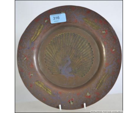 A stunning 19th century Turkish brass plate having enamel overlay Peacock scene to the centre with a colourful enamel border.