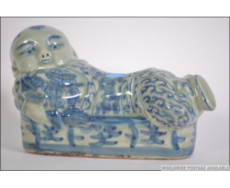 A Chinese blue and white ceramic pillow in the form of a recumbant buddha ( see illustrations ). Measures 23cm long.