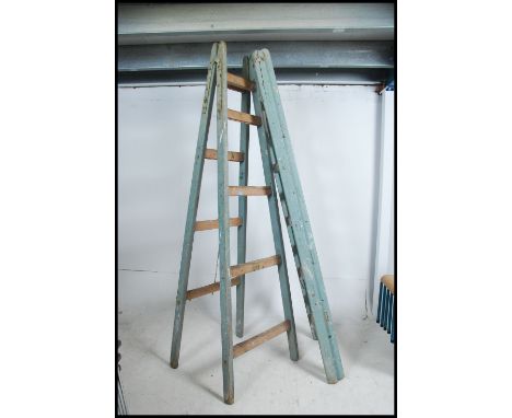 A pair of vintage mid century vintage wooden builders trestle stands with metal clasp to the top, painted frames. Measures 24