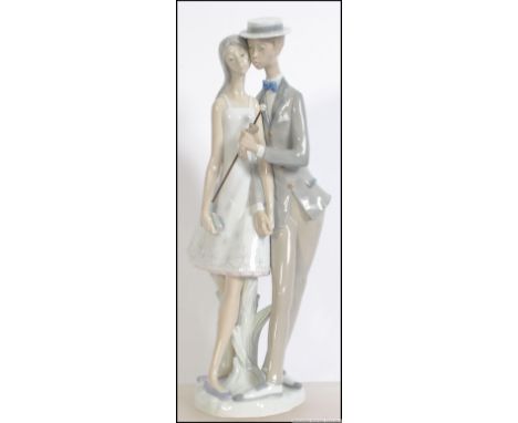 A Lladro 20th century Spanish ceramic figure group diorama of a young couple having impressed Lladro stamps to the base. Meas