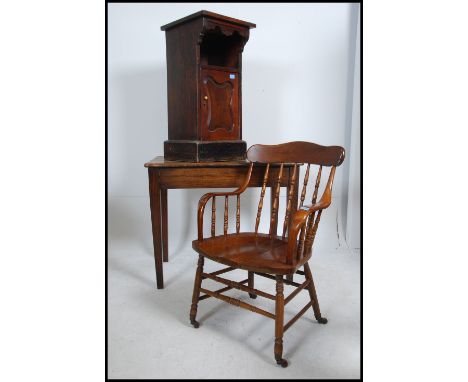 A 20th century smokers bow armchair with saddle seat and railed back rest together with a pedestal cupboard and a oak rustic 