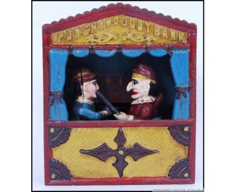 A vintage style, 20th century cast iron money bank of Punch and Judy in their puppet theatre. 