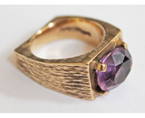 A hallmarked 9ct gold chunky ring set with a large amethyst coloured stone, gross wt. 13.8g.