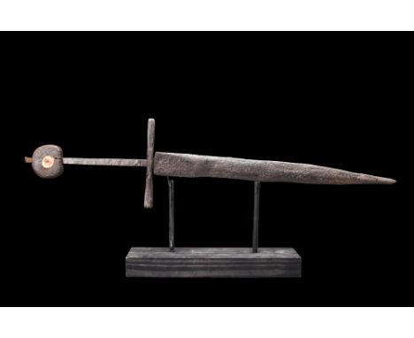 Ca. 1300-1500 AD. An iron double-edged dagger with a straight sculptured cross guard with incised decoration and tapering tan