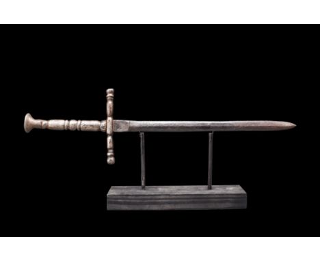 Ca. 1400-1500 AD. A Medieval dagger/stiletto with a long thin blade and handle. The cross guard is a square section bar in th