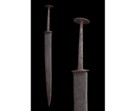 Ca. 1400-1500 AD. An iron dagger or stiletto featuring a double-edged slender blade with a button-shaped cross guard, rectang