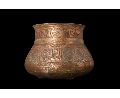 Ca. 14th century AD. A copper bowl featuring a rounded base on top of three small feet. Its sides gradually taper to a tubula